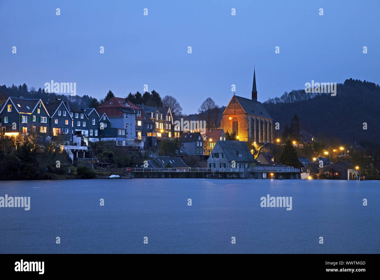frozen storage lake Beyenburger Stausee with church St Maria Magdalena in the blue hour, Wuppertal Stock Photo