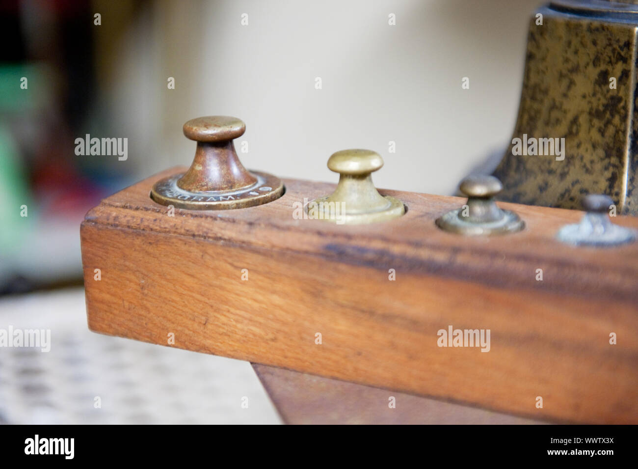 Old fashioned metal weights in wooden tray Stock Photo