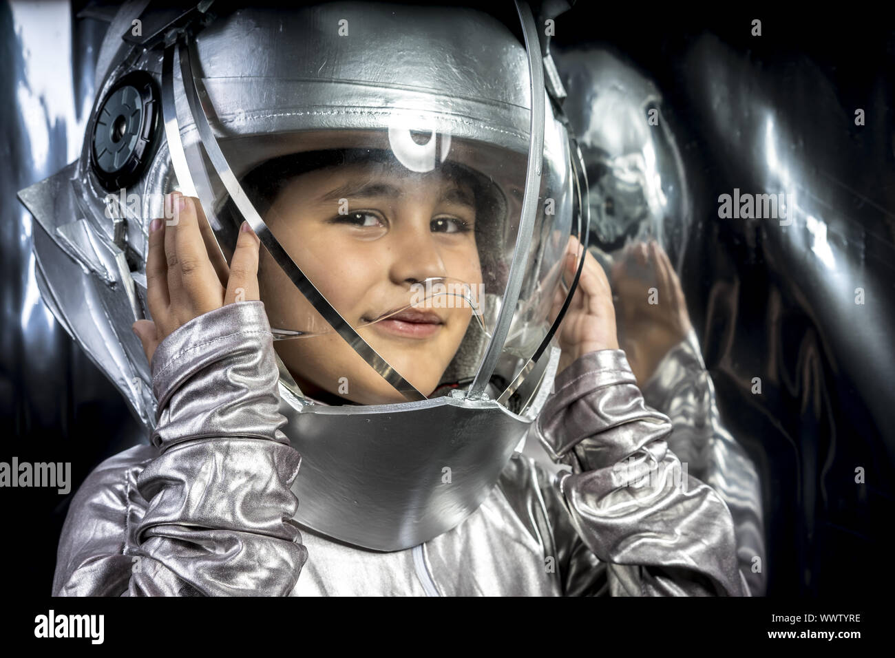 Boy playing to be an astronaut with a space helmet and silver suit on