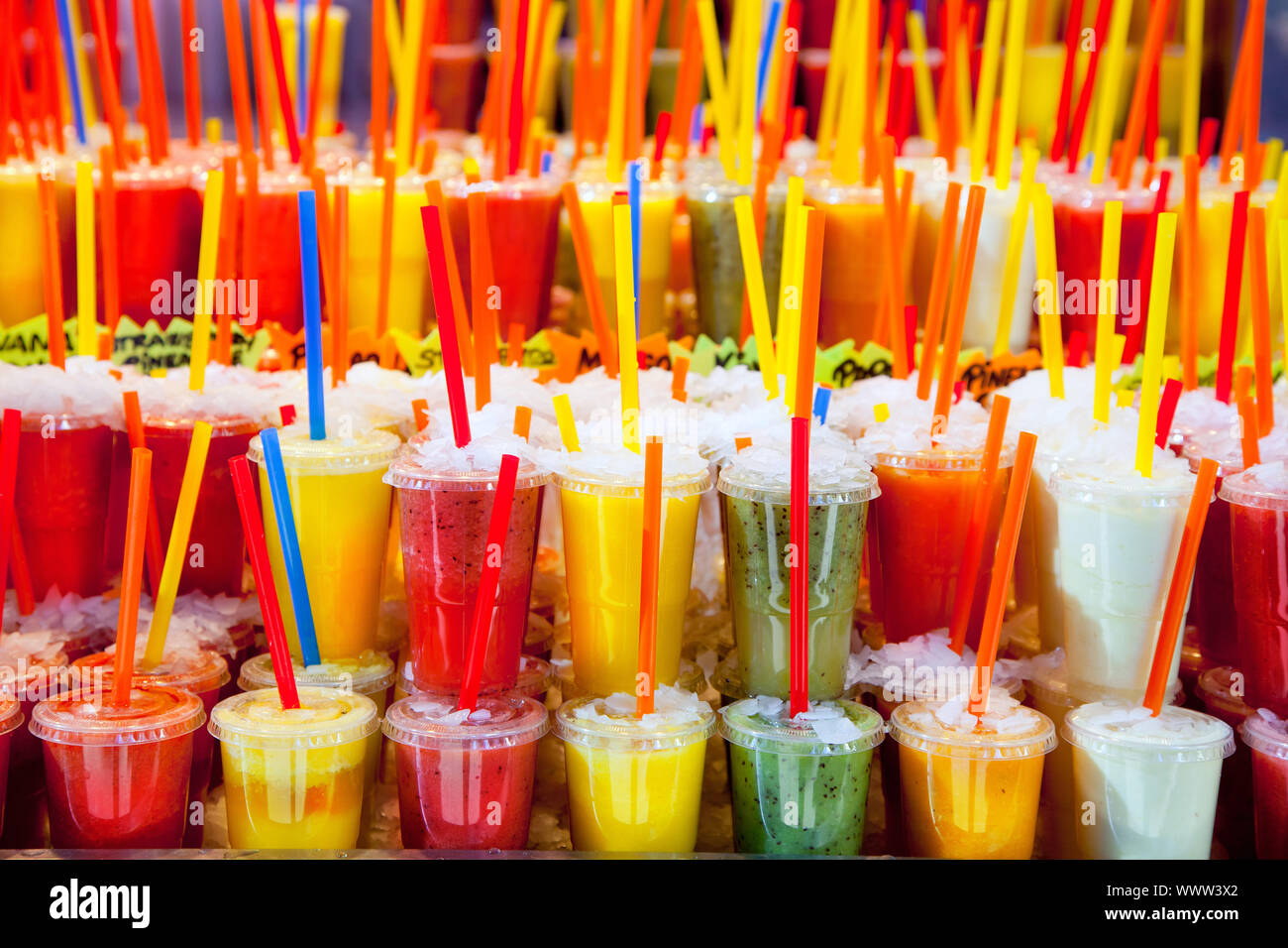 Colorful natural fresh fruits juice glasses with straw stacked in rows
