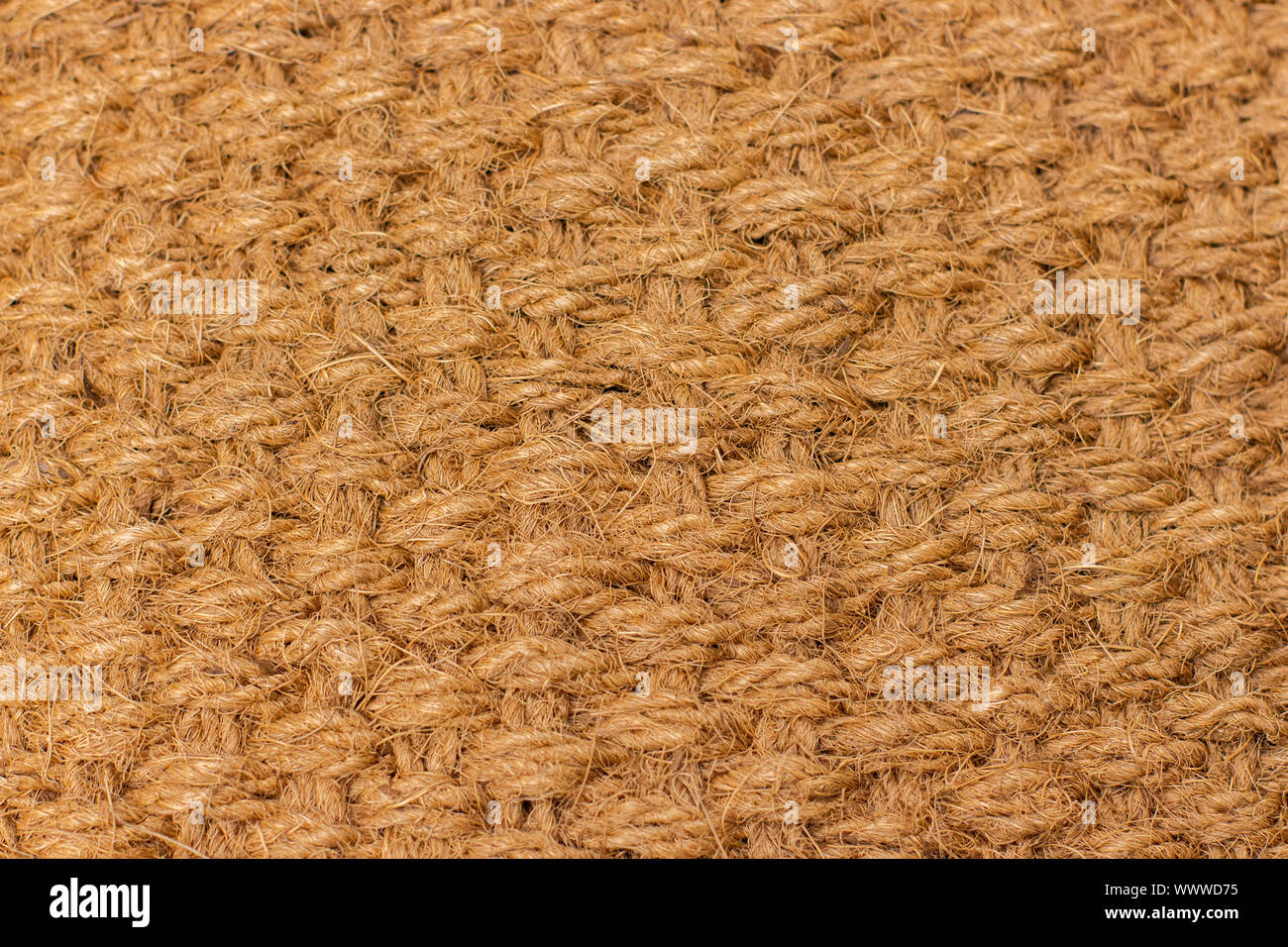 Background texture of natural material matting, cannabis hemp fiber. Material woven from natural hemp. Texture weaving of plaits of thick threads yell Stock Photo