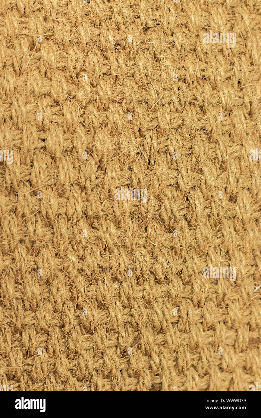 Background texture natural material braided from natural hemp, fiber from cannabis. Texture weaving of plaits of thick threads yellow beige vertical Stock Photo