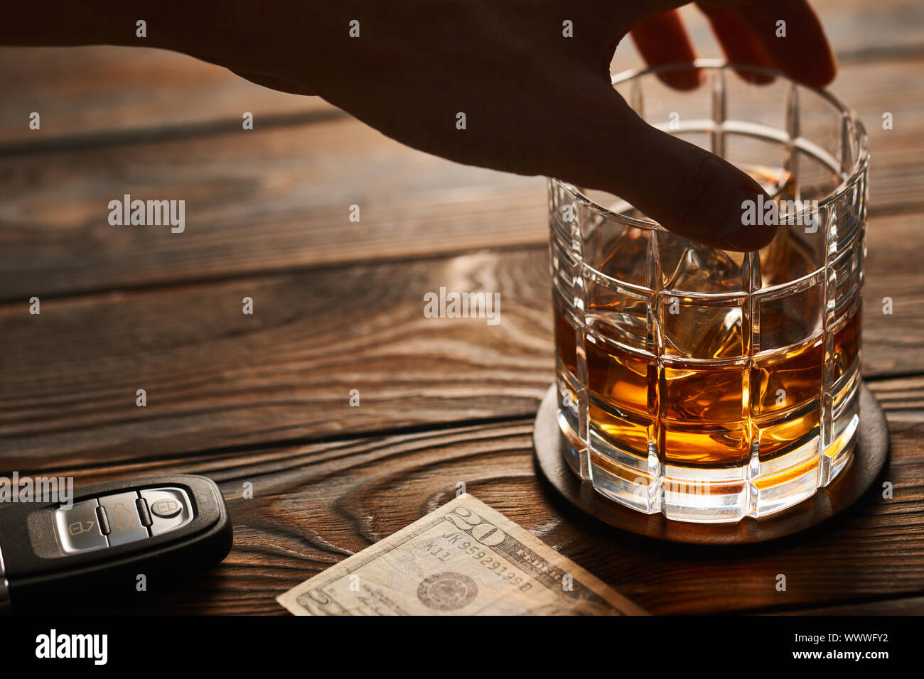 Man's hand reaching to glass with alcohol drink and car key. Drink and ...