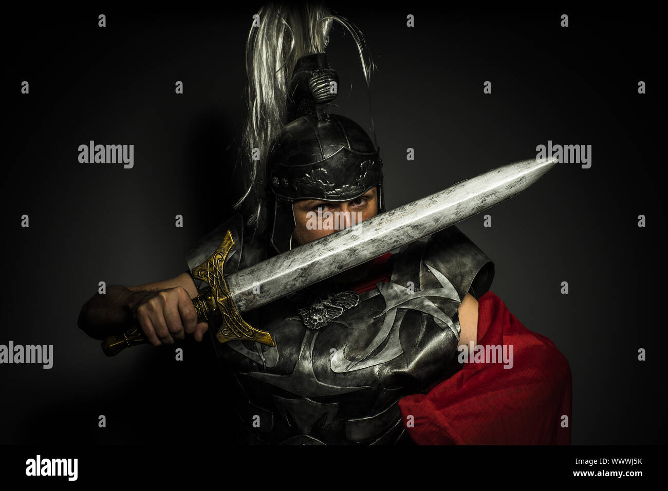 Glory, Roman centurion with armor and helmet with white chalk, steel sword  and long red cape Stock Photo - Alamy