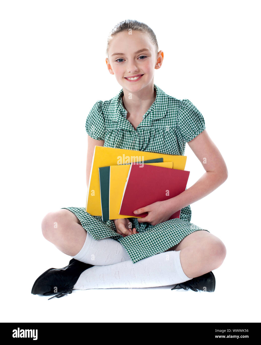 Beautiful girl sitting on floor with books in her arms Stock Photo - Alamy
