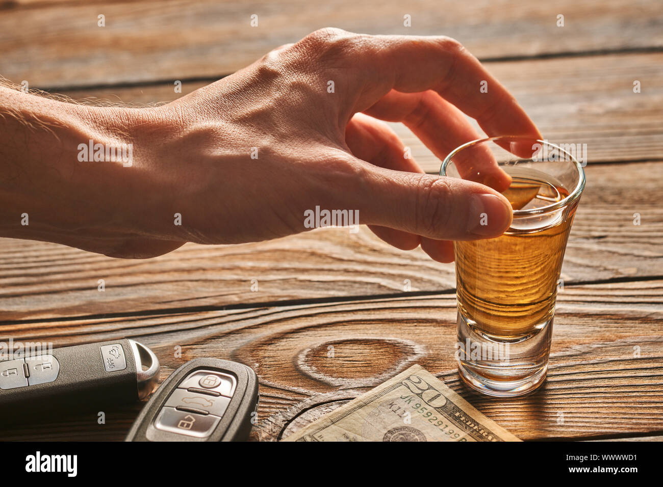 Man's hand reaching to glass with alcohol drink and car key. Drink and ...