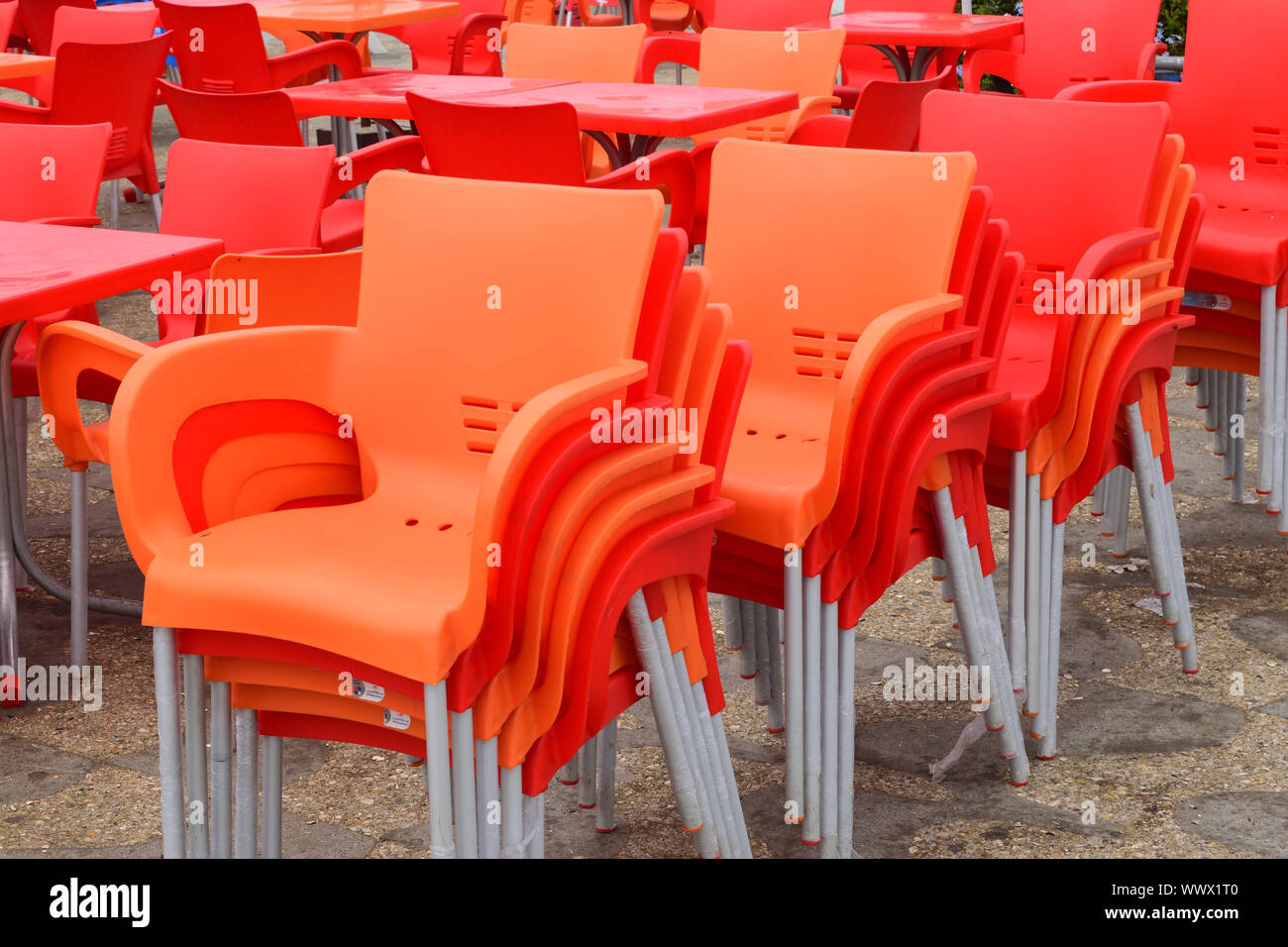 group of orange empty chairs of plastic in row Stock Photo