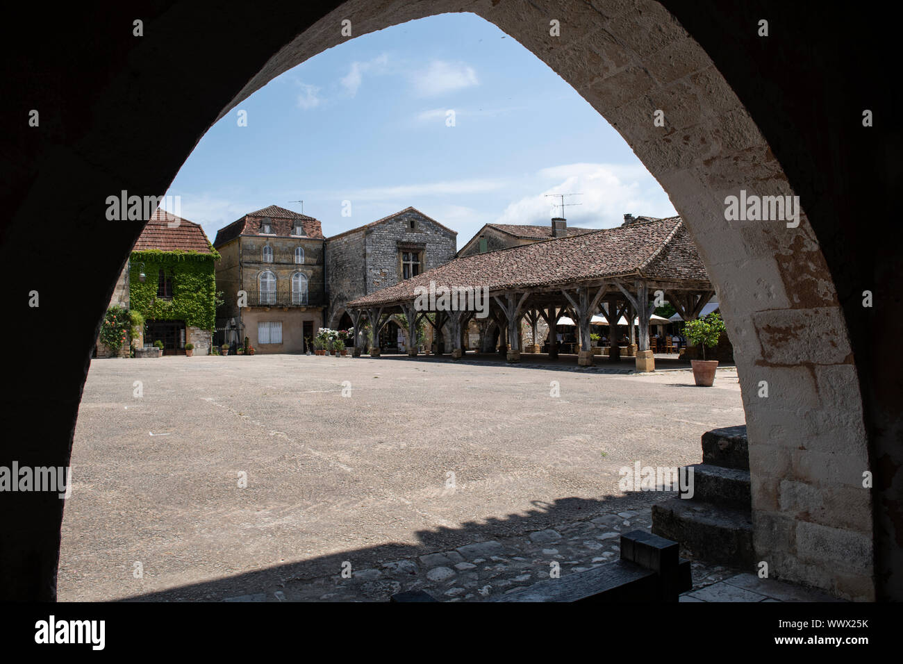 The main square of Monpazier, viewed through an archway Stock Photo