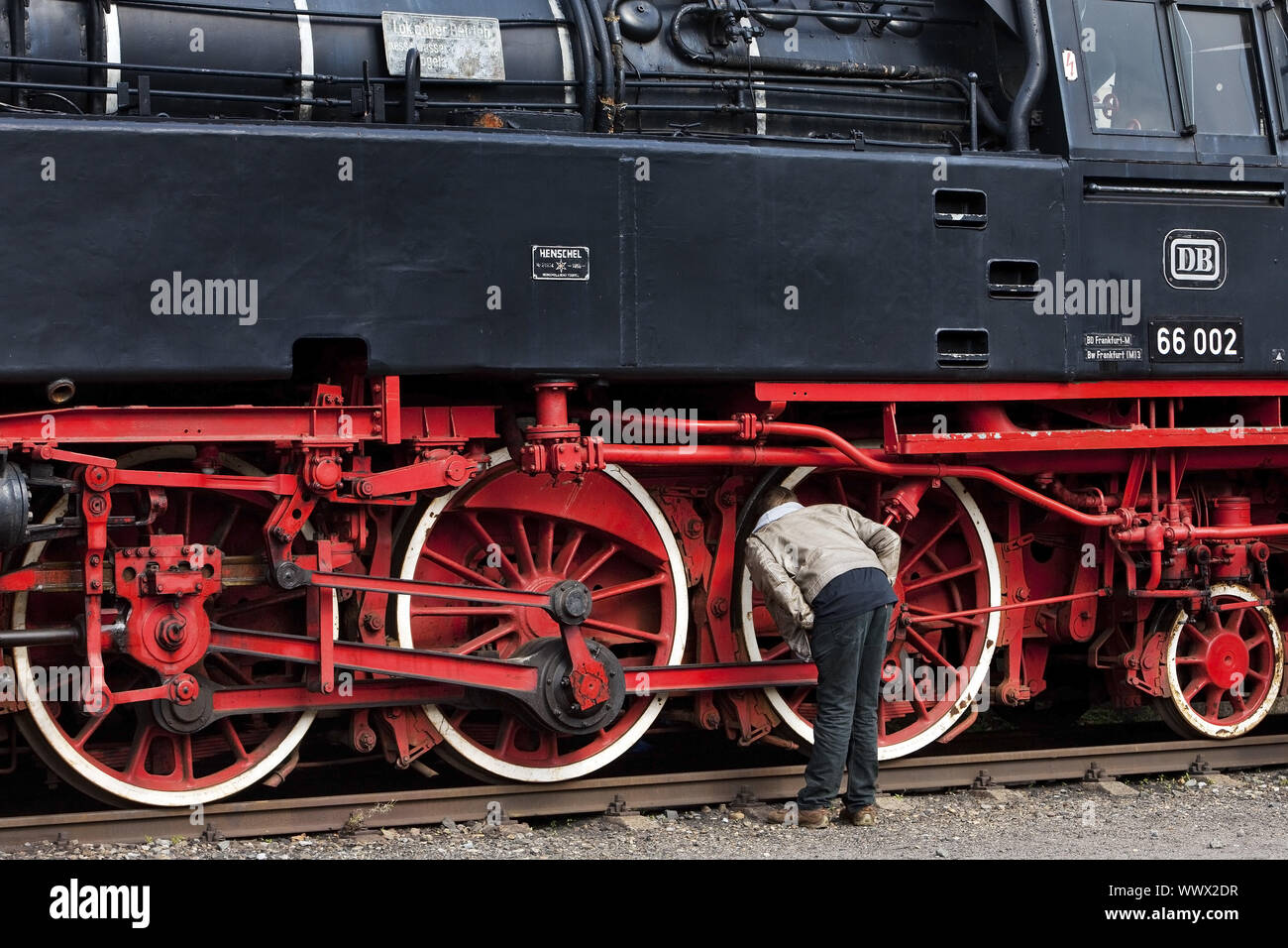 visitor looking at the wheels of an old steam Bochum