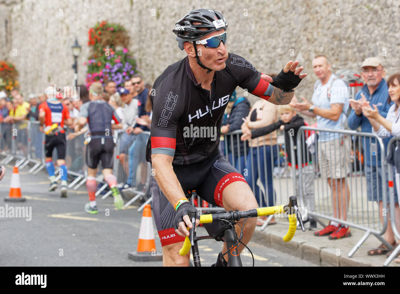 Tenby, UK. 15th Sep, 2019. Pictured: Gareth Thomas sends kisses to fans during the last mile of the cycle race. Sunday 15 September 2019 Re: Ironman triathlon event in Tenby, Wales, UK. Credit: ATHENA PICTURE AGENCY LTD/Alamy Live News Stock Photo