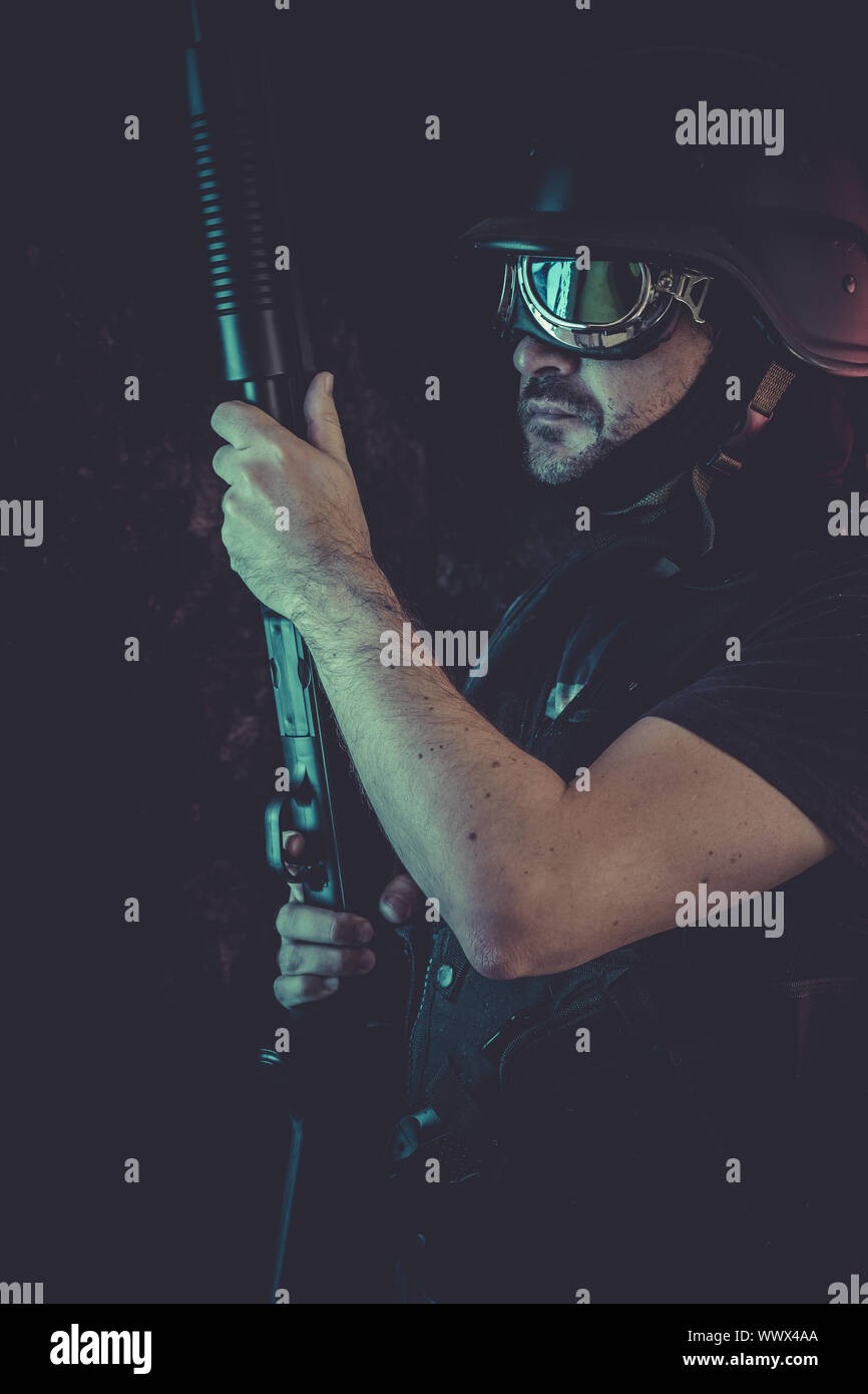 man armed with balaclava and bulletproof vest, gun and shotgun