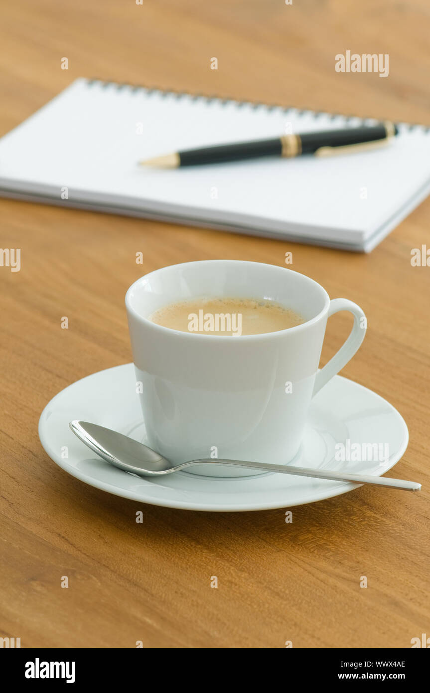 https://c8.alamy.com/comp/WWX4AE/white-coffee-cup-with-writing-utensils-on-a-wooden-table-WWX4AE.jpg