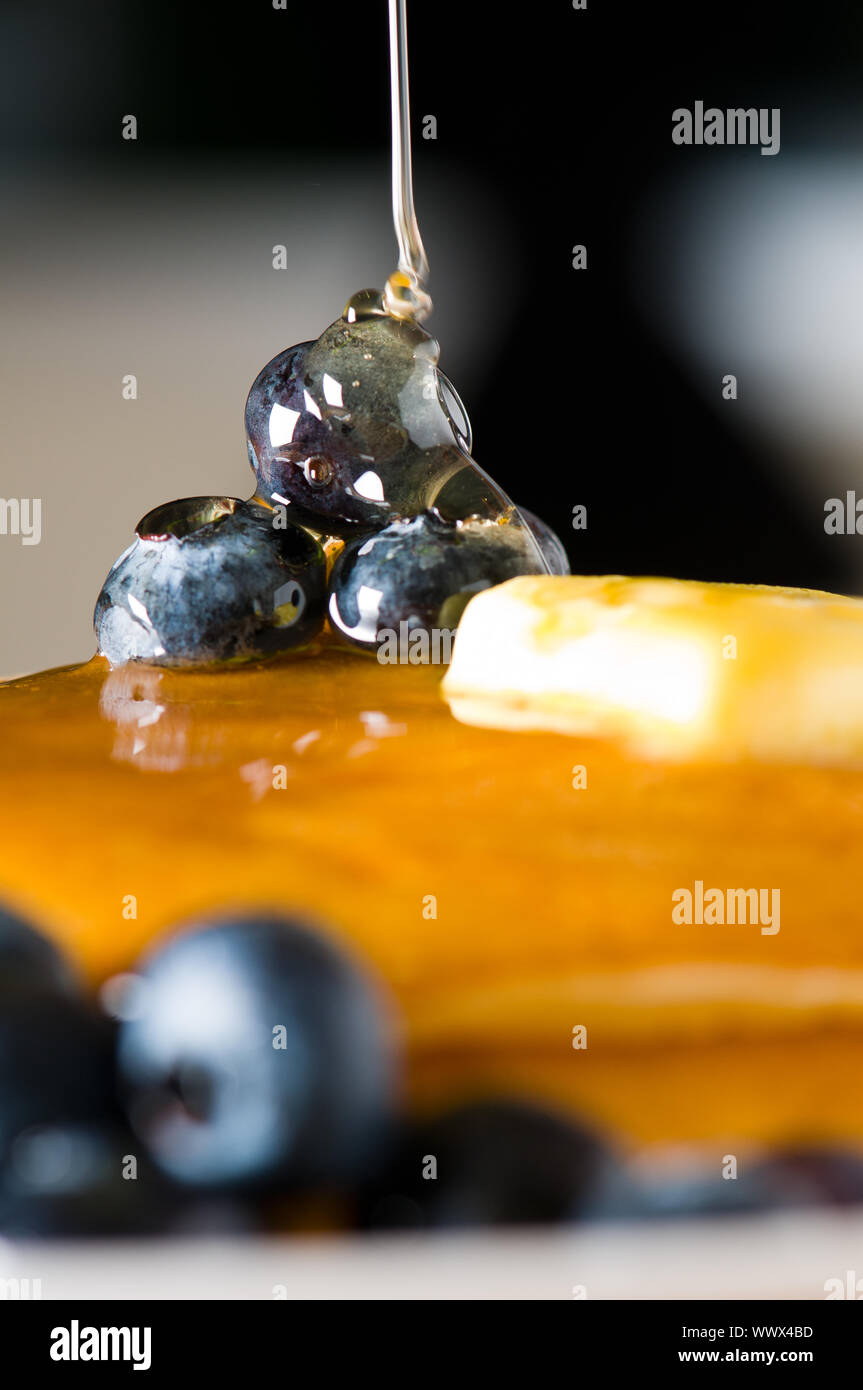 Blueberry butter pancake with honey/ maple sirup flowing down Stock