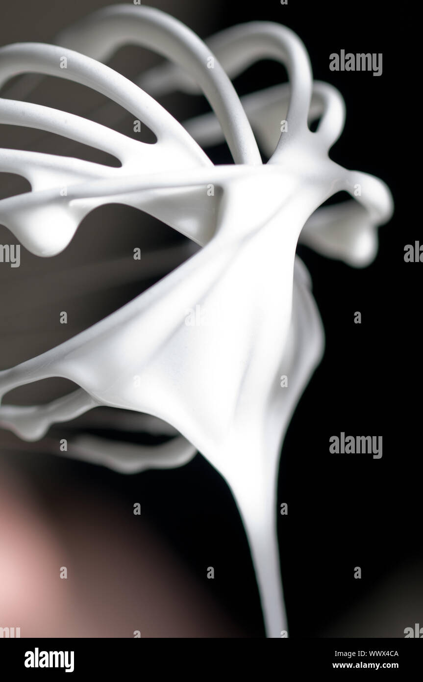 Whisk with creamy egg white close up flowing nicely down Stock Photo