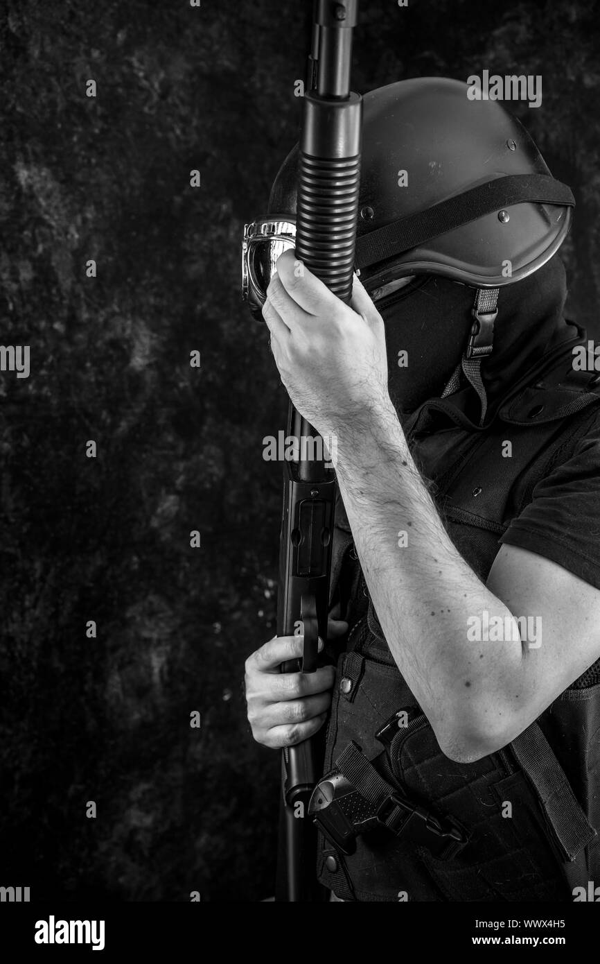 man armed with balaclava and bulletproof vest, gun and shotgun, kalashnikov Stock Photo