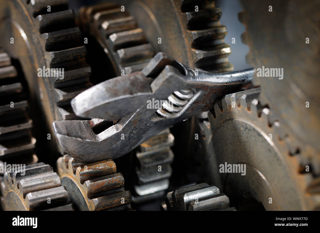 Adjustble wrench stuck between cog gear wheels Stock Photo Alamy