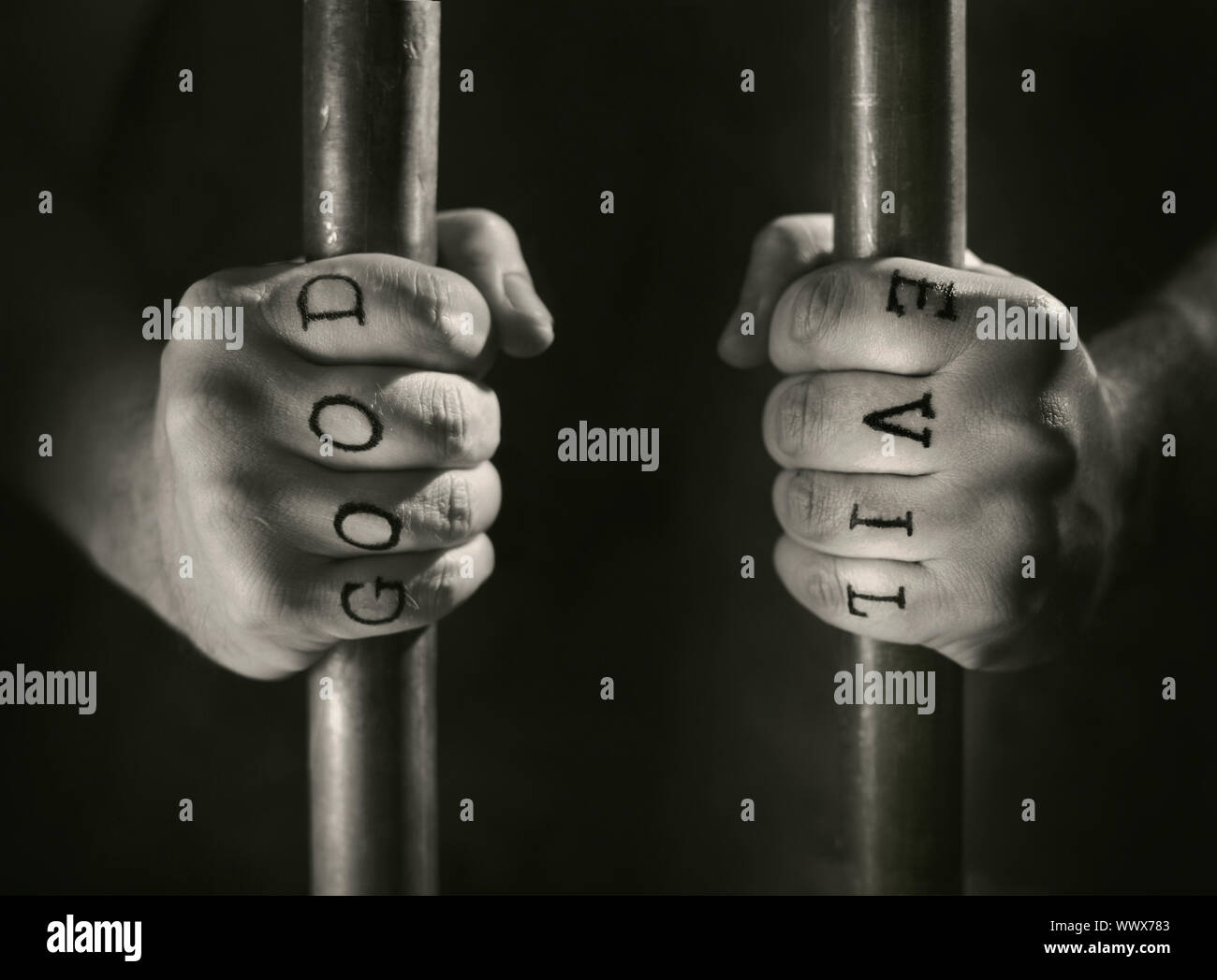 Man with (fake) Good and Evil tattoos behind prison bars. Stock Photo