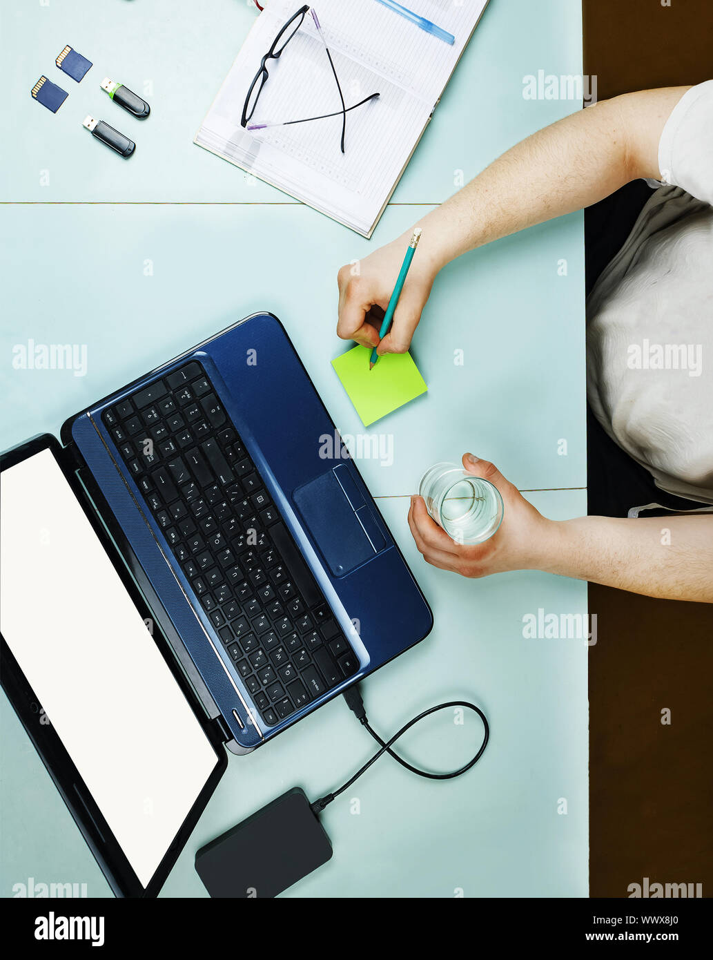 Young freelancer working at home at a table using a laptop Stock Photo