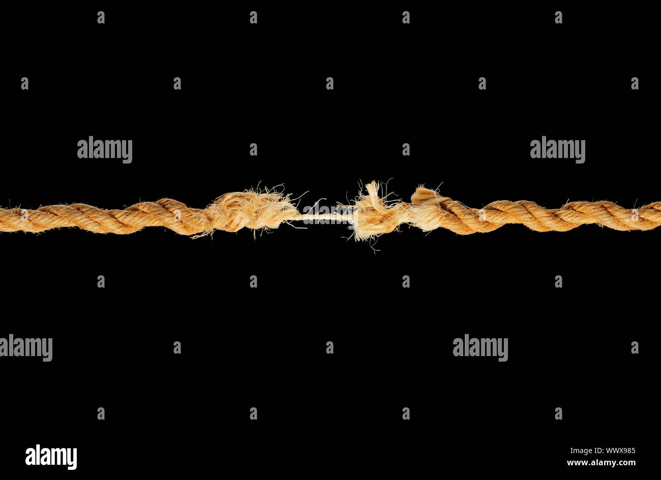 Breaking Rope Link A natural fibre rope breaking against black background Stock Photo - Alamy