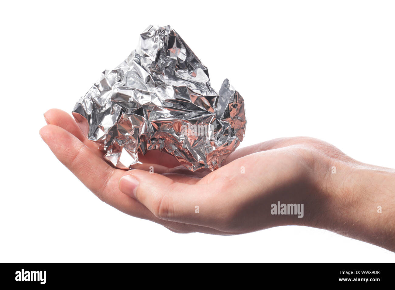 Hand holding a crumpled aluminum foil wrap Stock Photo