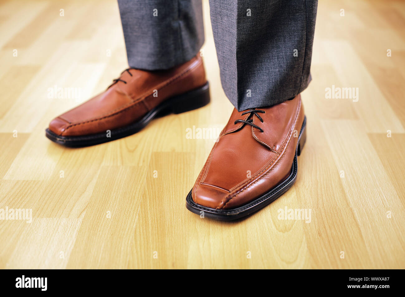 Feet with brown leather shoes. short 