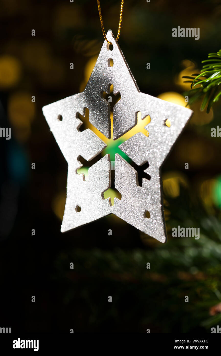 Decorative Silver Star ornament in a Christmas tree infront of a ...