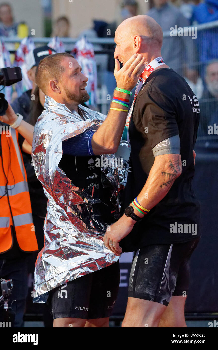 Tenby, UK. 15th Sep, 2019. Pictured: Gareth Thomas (R) is embraced by former Wales international rugby team mate Shane Williams by the finish line. Sunday 15 September 2019 Re: Ironman triathlon event in Tenby, Wales, UK. Credit: ATHENA PICTURE AGENCY LTD/Alamy Live News Stock Photo