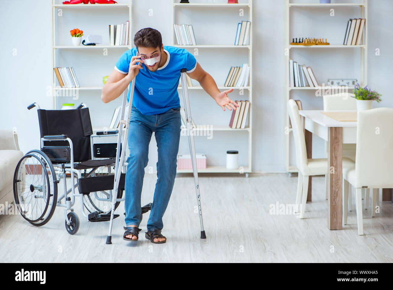 Young man recovering after surgery at home with crutches and a w Stock Photo