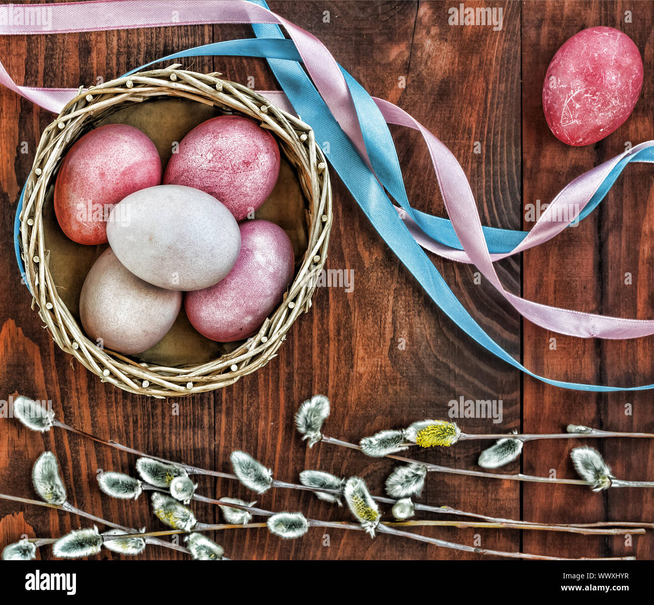 Easter. Multi-colored Easter eggs in a basket, willow, colored tape. top veiw. Stock Photo
