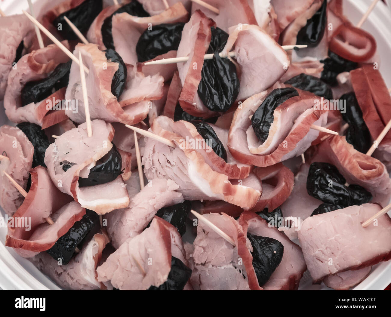 Snack: ham and prunes in thin sticks. Stock Photo