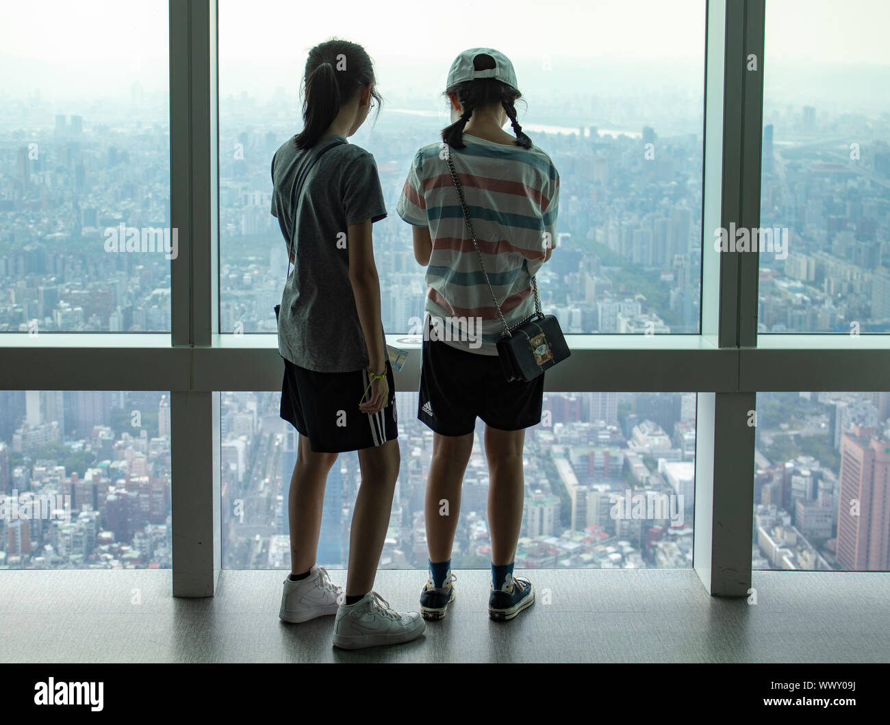 Two tourists looking out over the smog covered city of Taipei Stock Photo