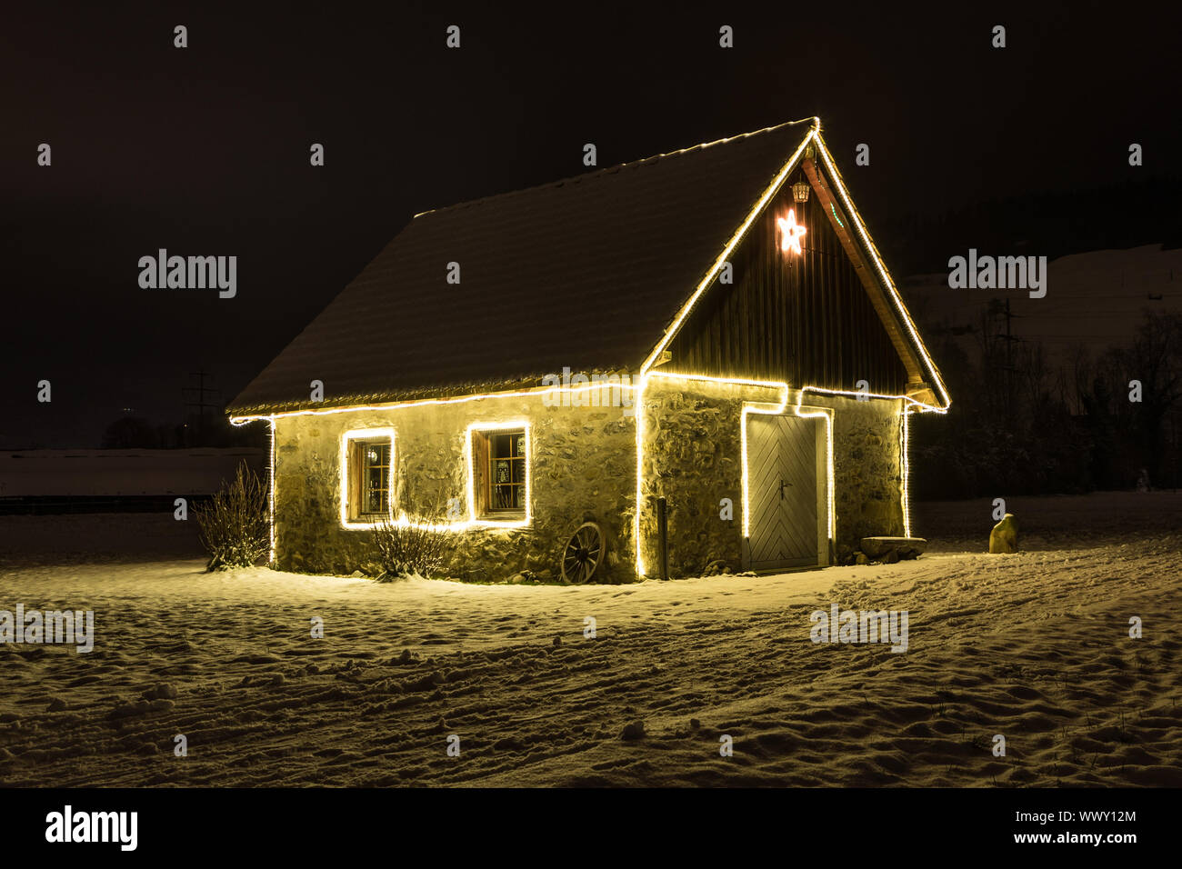 Small cottage with fairy lights at night and snow, Malters, Lucerne, Switzerland, seasons Stock Photo