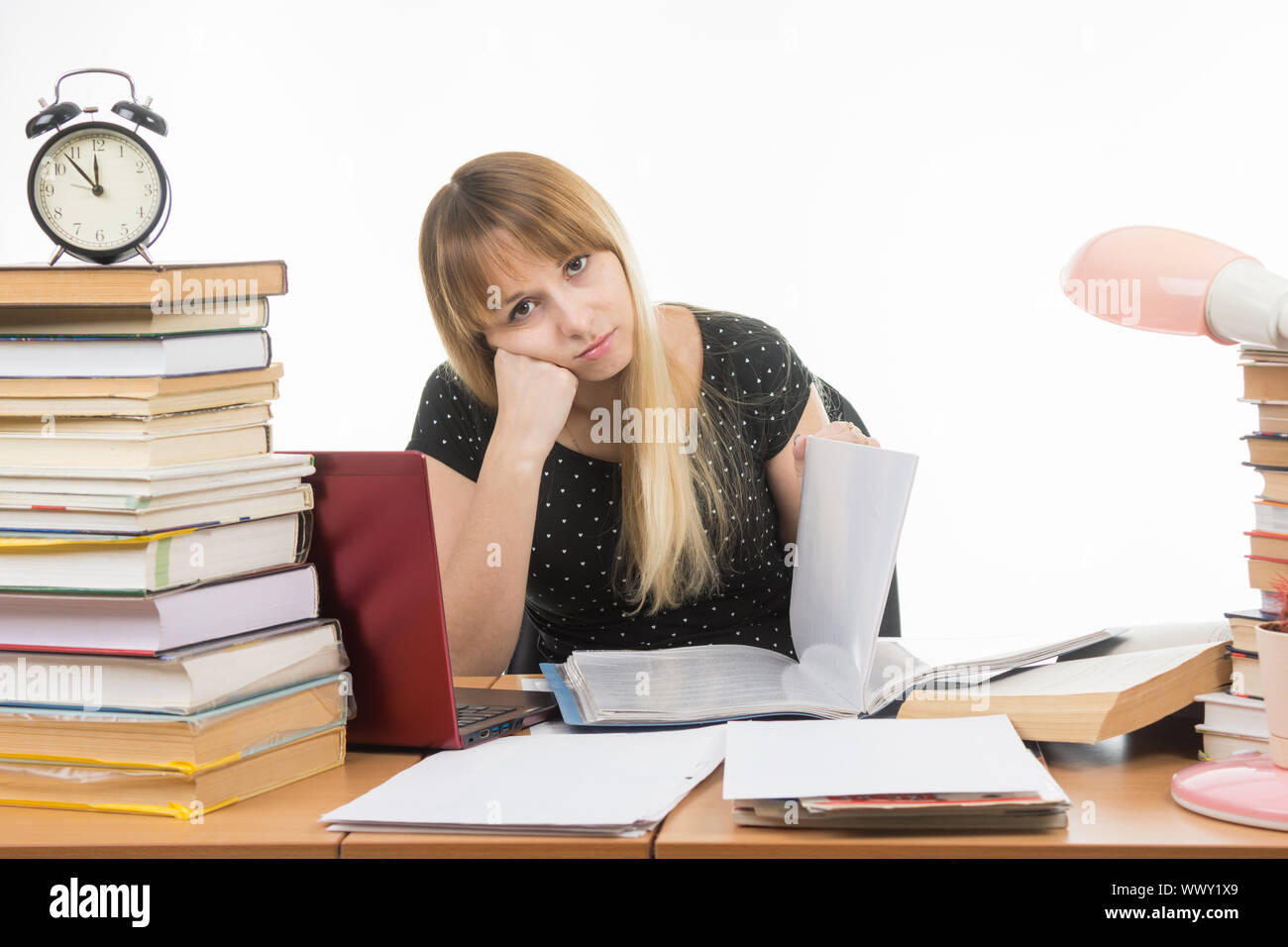 Student paper dull leafs at a table among books and stacks of looks in the picture Stock Photo