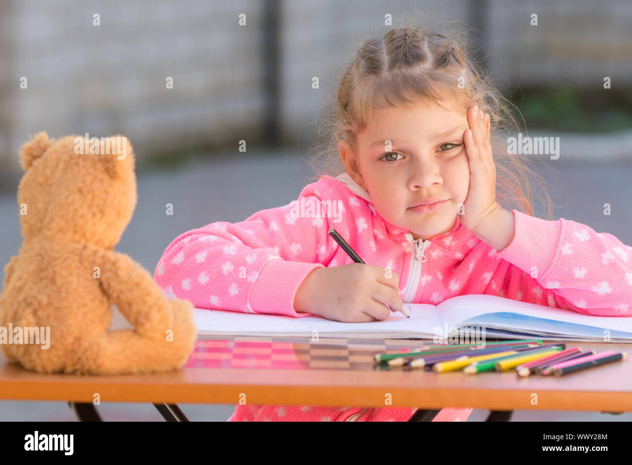 The girl does not know how to continue to draw drawing pencils Stock Photo