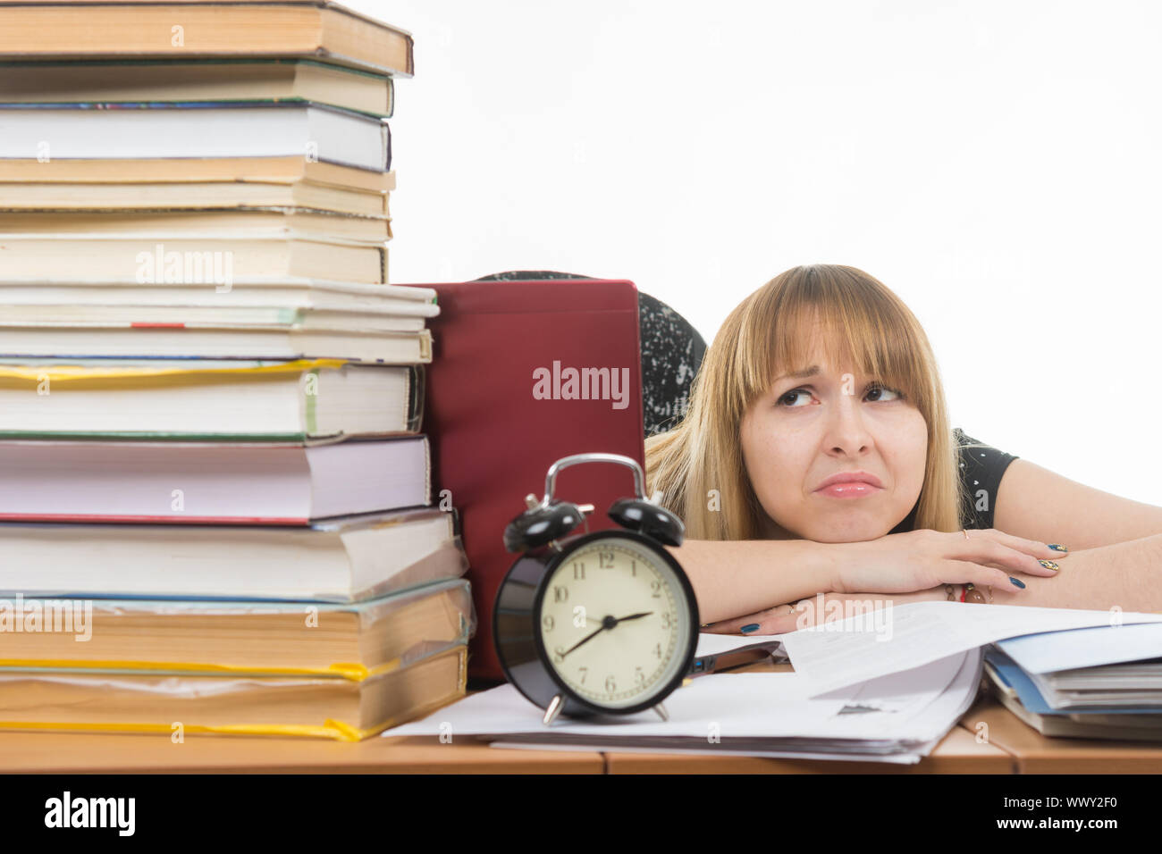 Student with despair looking at a big stack of books Stock Photo