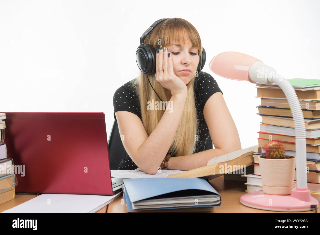 Student falling asleep reading a reference book Stock Photo