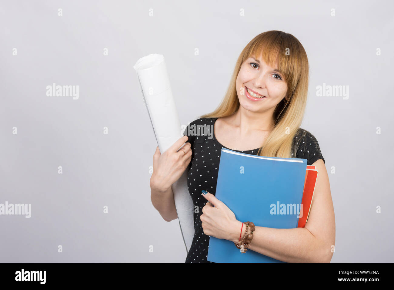 Girl student smiling and holding blueprints and a folder with documents Stock Photo