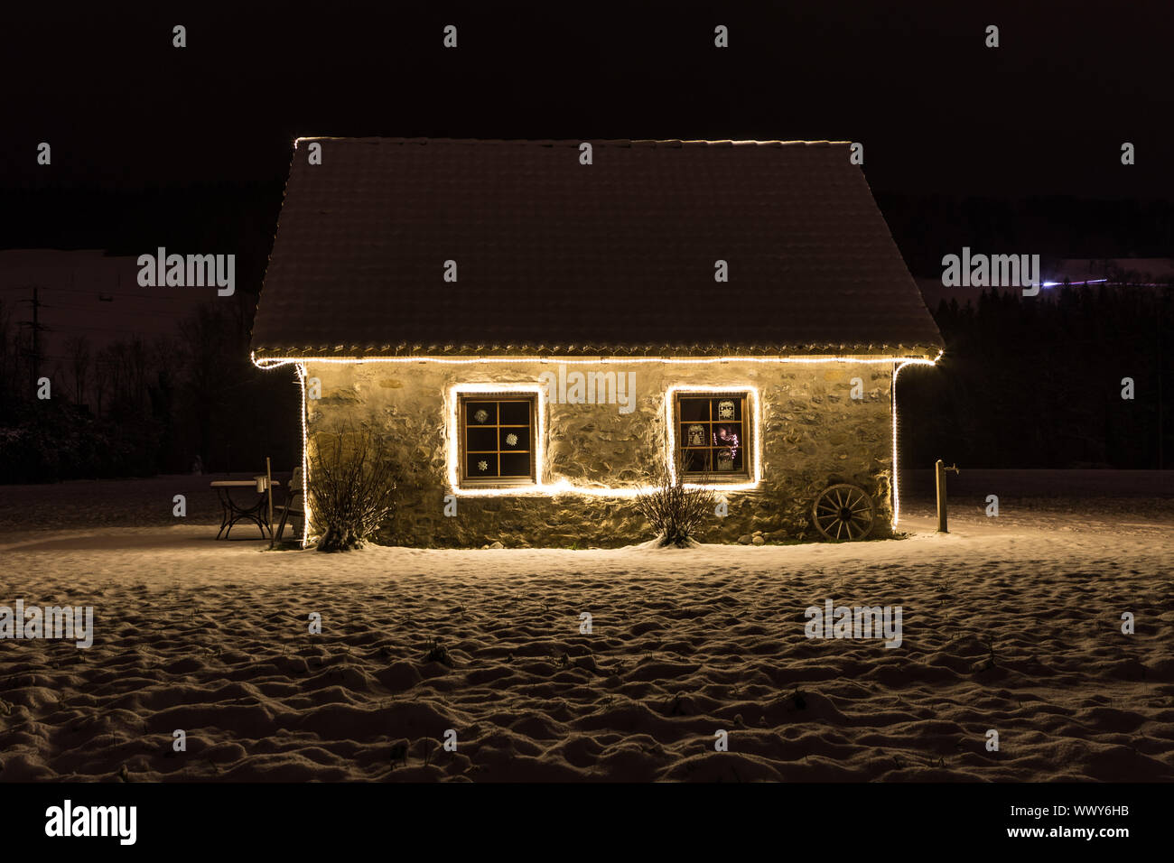 Small cottage with fairy lights at night and snow, Malters, Lucerne, Switzerland, seasons Stock Photo