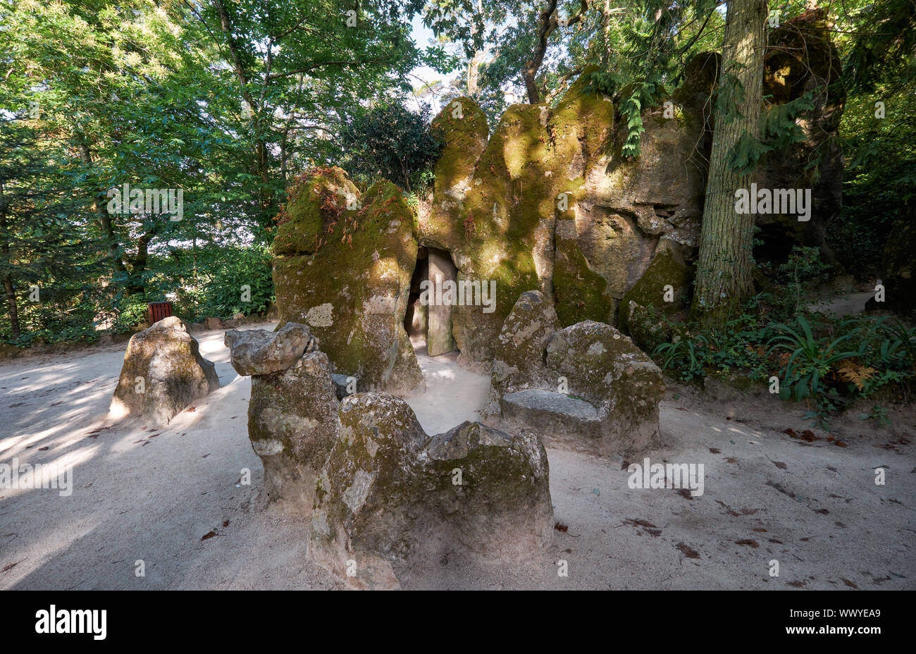 Mossy stones hiding the entrance to Initiation Well in Quinta da Regaleira. Sintra. Portugal Stock Photo