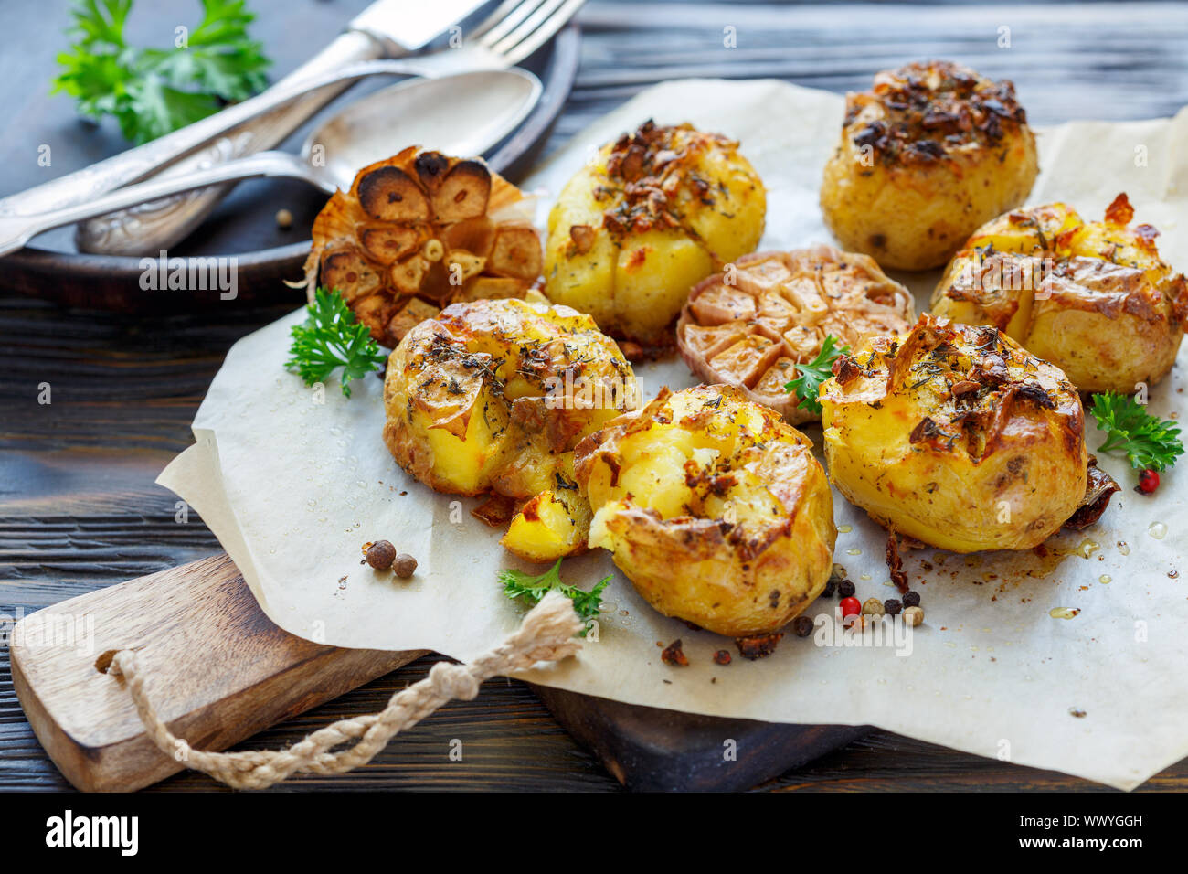 Baked potatoes in skin with spices, olive oil and garlic Stock Photo