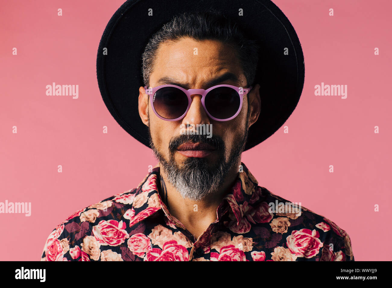Portrait of a man with beard, hat and sunglasses, isolated in a studio ...