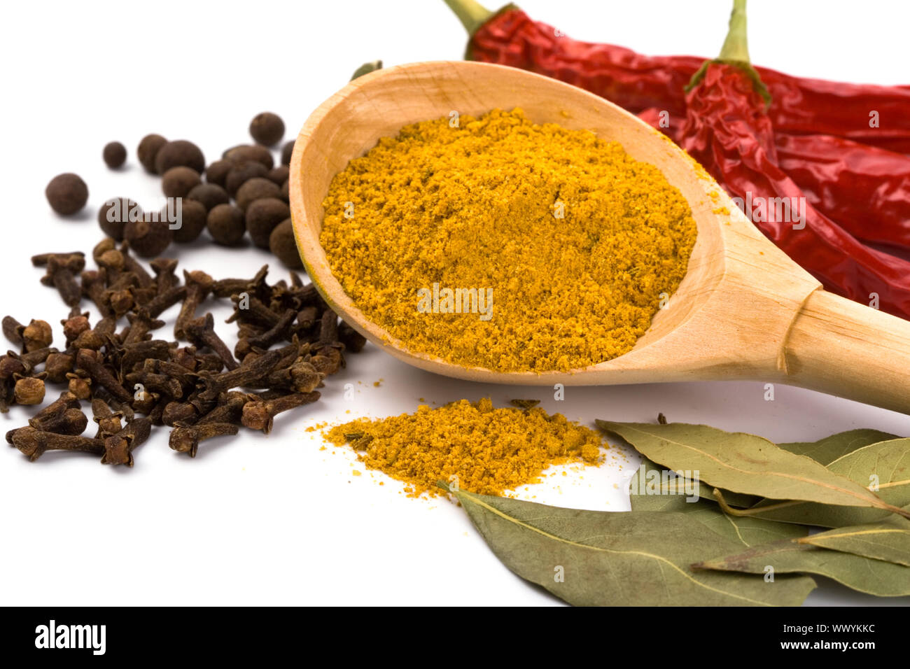 spices curry in wooden spoon, pepper, pimento, cloves and bay leaves