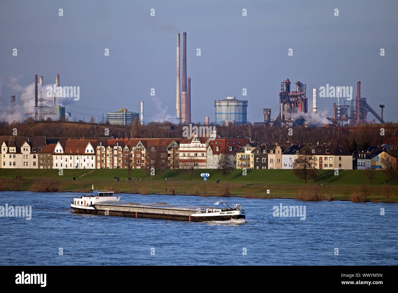 cargo ship on river Rhine and industrial scenery in background, Duisburg, Germany, Europe Stock Photo
