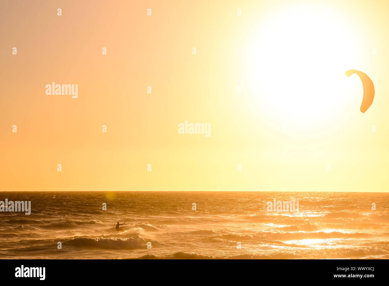 Surfer at sunset on a calm ocean Stock Photo