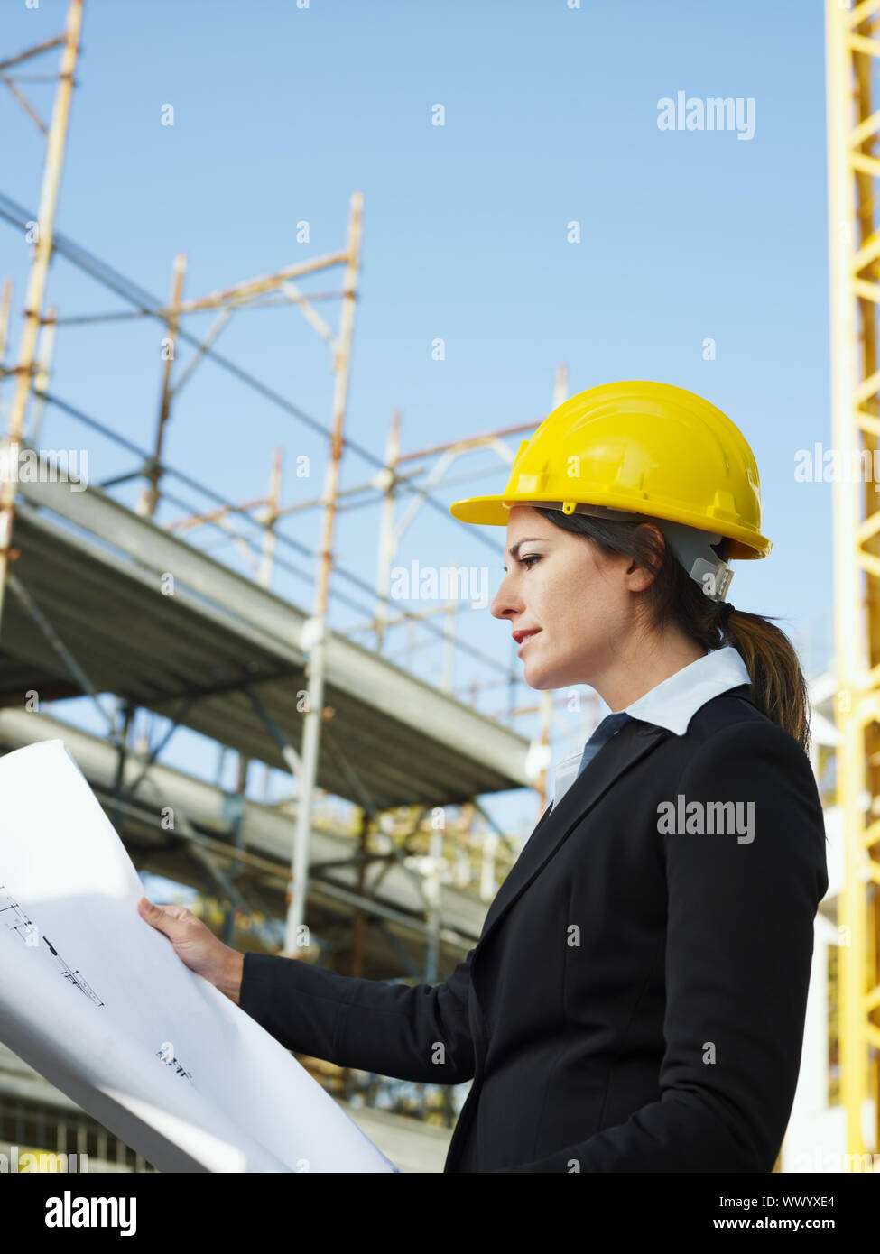 female engineer holding blueprints in construction site Stock Photo - Alamy