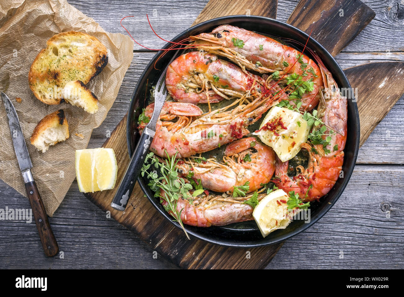Traditional fried black tiger prawn with garlic bread as top view in a