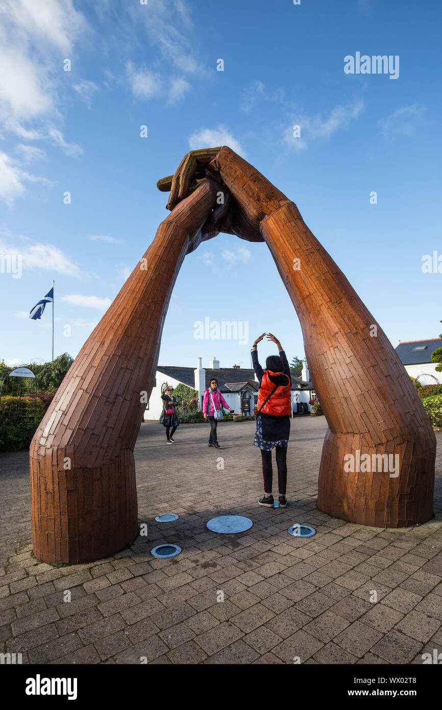 Tourists pose infant of 'The Big Dance' a sculpture by Ray Lonsdale in Gretna Green Scotland Stock Photo