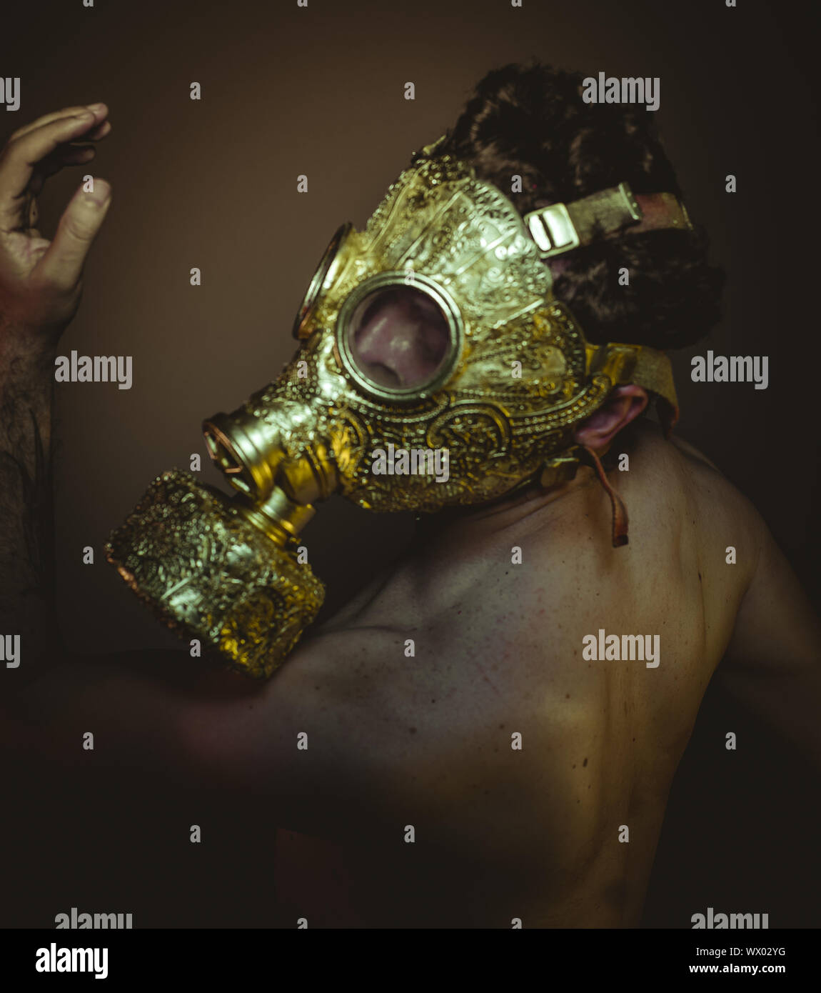 Protective, Man with gold gas mask and arabesques in poses of drowning and  desperation, depression and psychiatry concept Stock Photo - Alamy