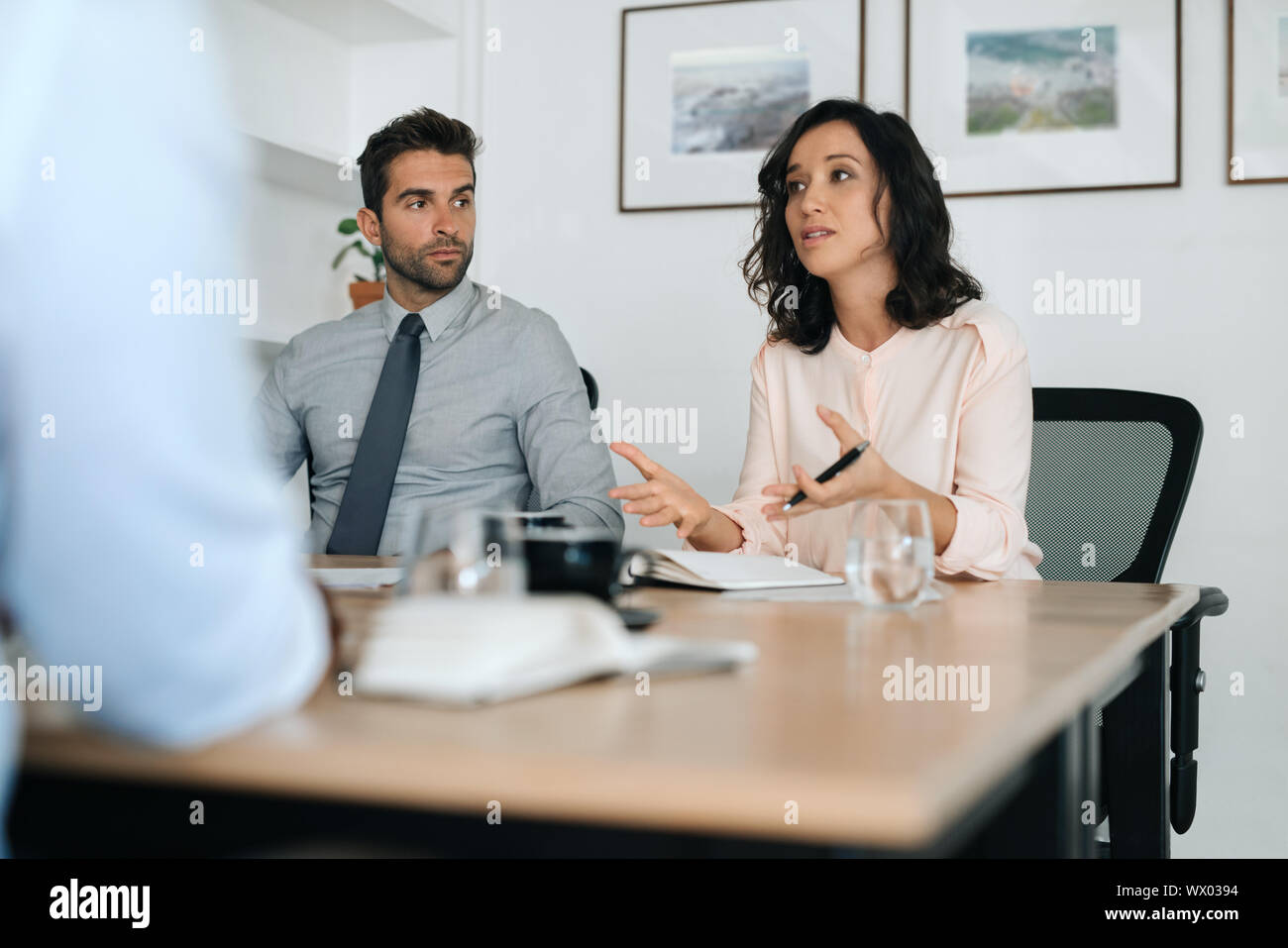Young businesswoman explaining ideas to coworkers during an office meeting Stock Photo