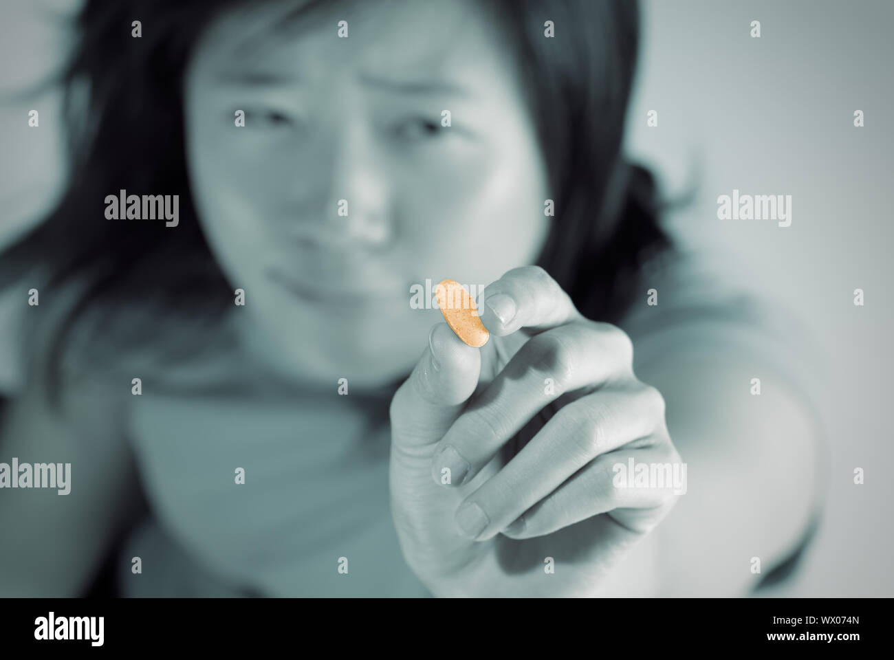 Woman ill holding tablet with ache expression Stock Photo - Alamy